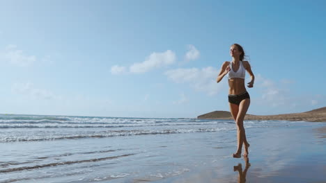 Healthy-woman-running-on-the-beach,-girl-doing-sport-outdoor,-happy-female-exercising,-freedom,-vacation,-fitness-and-heath-care-concept-with-copy-space-over-natural-background